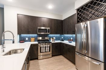 A kitchen with stainless steel appliances and wooden cabinets